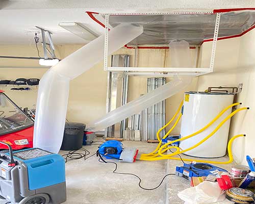 Roof Leaks / Tarping solution with drying machines in a garage to fix roof leaks by Stallion Restoration