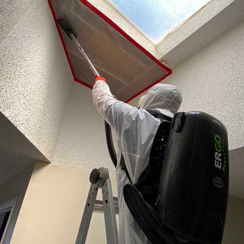 man performing Water Remediation Services and Mold Remediation on a damaged ceiling with Stallion Restoration