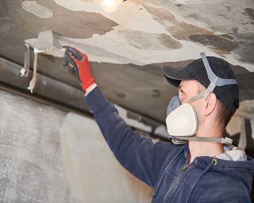 man performing Fire Damage Restoration on a ceiling with Stallion Restoration